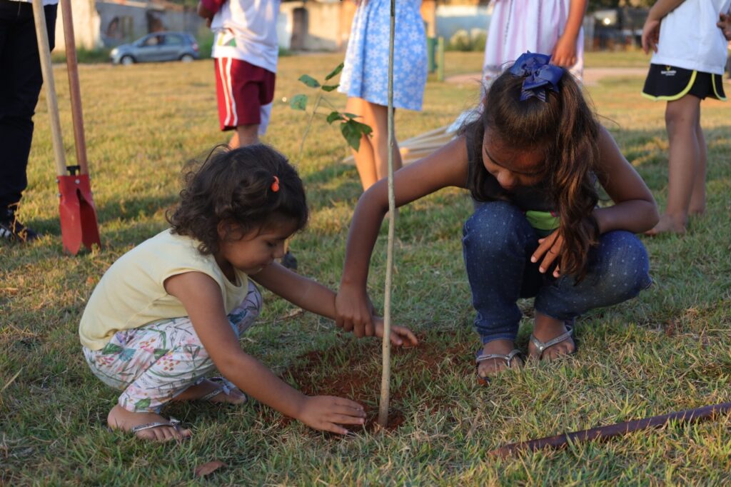 Pais e filhos plantam ipês na Praça Cinco Estrelas, no Setor Santo André